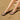 Black Archies flip flops worn on feet standing on sand