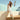 Person wearing mint Archies Flip Flop and white dress sitting on a wall