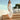 Woman in a white dress wearing orange Archies flip flops standing on wooden steps outdoors