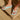 Sky blue flip-flops worn on feet standing on a wooden floor