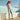 woman stadning poolside wearing tan Archies flip flops