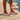 Person wearing crystal white Archies flip flops on a wooden floor with a close-up of the crystal on the flip flop thong