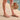 Person wearing crystal taupe Archies flip flops on a wooden floor with a close-up of the crystal on the flip flop thong